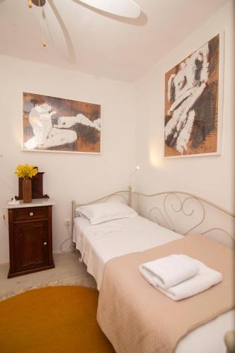 two beds in a room with paintings on the wall at Holiday Home ART - Bol in Bol