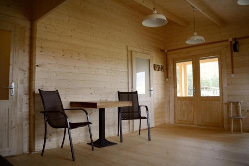 a wooden room with a table and chairs in it at Camping Szczecinek Domy Wypoczynkowe in Szczecinek