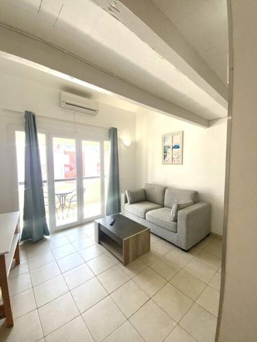 un salon avec un canapé et une table dans l'établissement Appartement proche de la plage d'Algajola, à Algajola