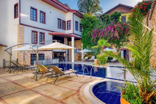 a courtyard with a swimming pool and a house at Dogan Hotel in Antalya