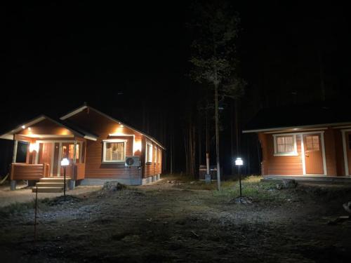 Lomanaamanka Naava-Cottage / Naava-hirsimökki في Syöte: كابينة بالليل فيها اضاءه