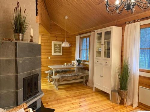 a large living room with a fireplace and a sink at Lomanaamanka Naava-Cottage / Naava-hirsimökki in Syöte