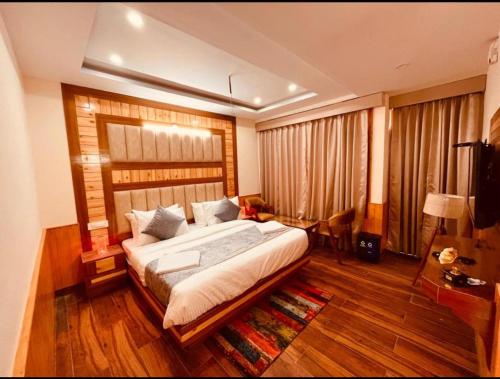 a bedroom with a large bed in a room with wooden floors at Hotel Lee Green- best family hotel in Darjeeling in Darjeeling