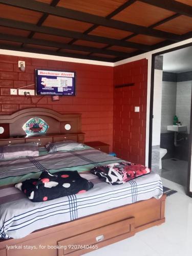 1 cama grande en un dormitorio con paredes rojas en Mistymout Homestay, en Attappādi