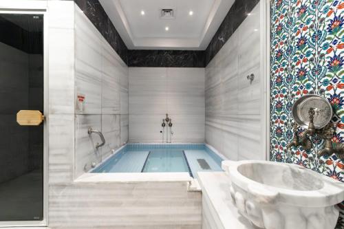 a bathroom with a tub and a swimming pool at Bonjur Hotel Thermal & Wellness Club in Ankara
