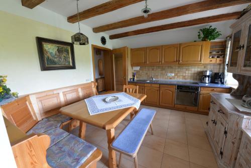 a kitchen with wooden cabinets and a table and chairs at Ferienwohnung Kurz in Rimsting