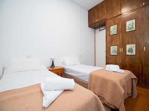 1 Schlafzimmer mit 2 Betten und einer Holzwand in der Unterkunft Apartamentos 3000 Escarrilla in Escarrilla