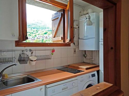 een kleine keuken met een wastafel en een raam bij Apartamentos 3000 Escarrilla in Escarrilla