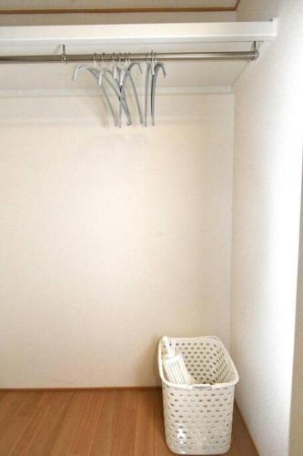 a room with a white wall and a basket at ゆったり1LDKで最大8人まで宿泊可能！博多駅・キャナルも徒歩圏内！コンビニ・スーパー徒歩１分！ in Sumiyoshi