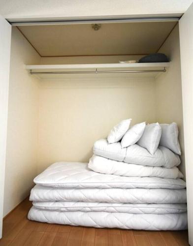 a stack of white towels in a room at ゆったり1LDKで最大8人まで宿泊可能！博多駅・キャナルも徒歩圏内！コンビニ・スーパー徒歩１分！ in Sumiyoshi