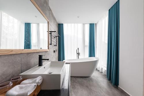 a bathroom with a white tub and a sink at Zhangjiajie Qiquan Vacation B&B in Zhangjiajie