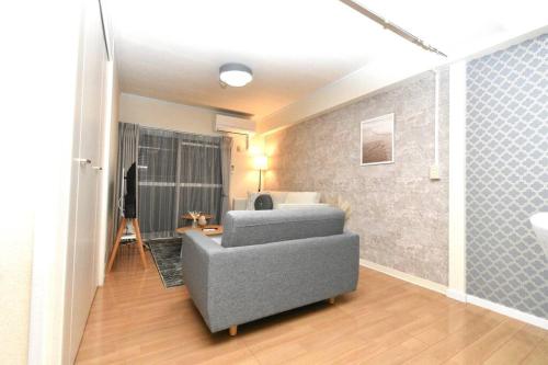 a living room with a couch and a bed at ゆったり1LDKで最大8人まで宿泊可能！博多駅・キャナルも徒歩圏内！コンビニ・スーパー徒歩１分！ in Sumiyoshi