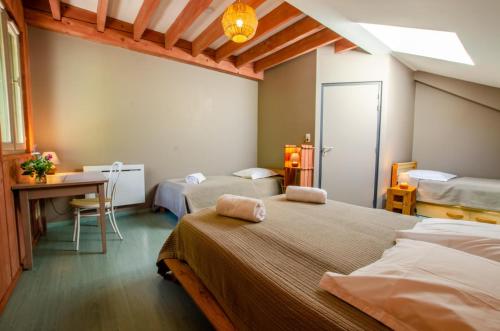 1 dormitorio con 2 camas, escritorio y mesa en La beuillotte, en Bar-sur-Seine