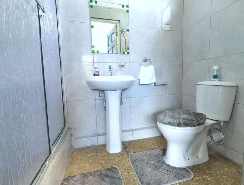 a bathroom with a toilet and a sink at Inviting 3-Bed Apt in Whim Estate- nearScarborough in Scarborough