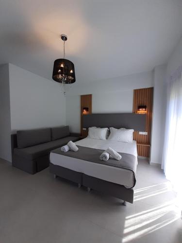 a bedroom with a bed and a couch at ACTA Luxury Rooms in Nikiti
