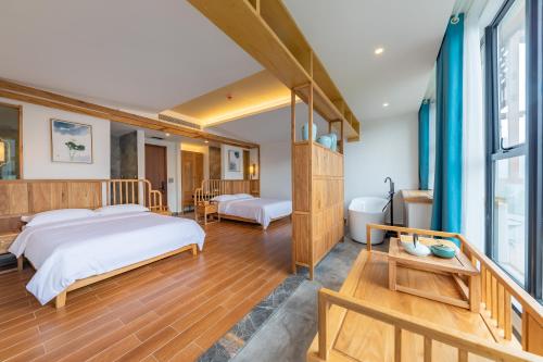 a bedroom with two beds and a bathroom at Zhangjiajie Qiquan Vacation B&B in Zhangjiajie