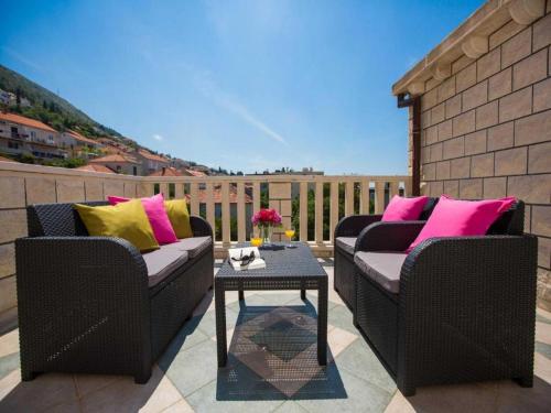 un patio con 2 sillas de mimbre y una mesa en City Apartments Lani en Dubrovnik