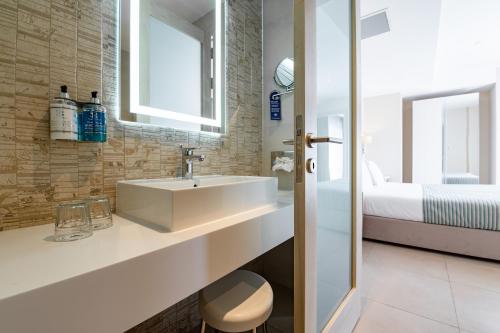 uma casa de banho com um lavatório e uma cama em Maritim Antonine Hotel & Spa em Mellieha