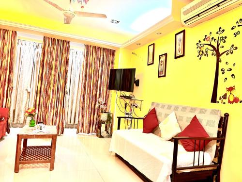 a living room with a white couch and yellow walls at Remarkable 3-Bed Apartment in Panjim in Panaji