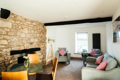 a living room with a stone wall at Rigney Bank House, South Lakes Luxury Apartments in Milnthorpe