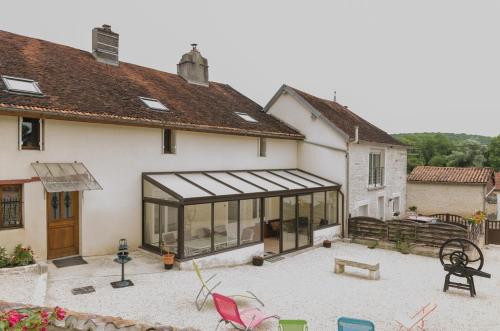 a large white house with a conservatory with windows at Chez albertine in Spoy