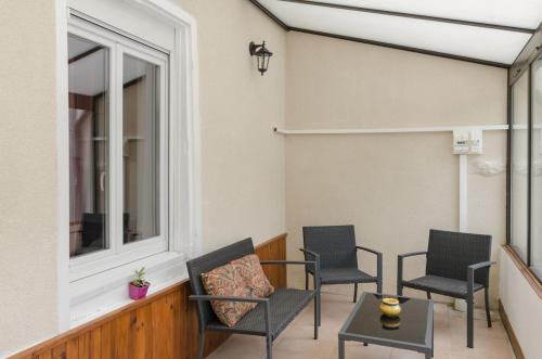a porch with chairs and a table and a window at Chez albertine in Spoy