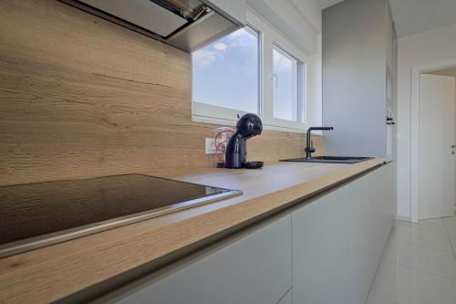a kitchen counter with a sink and a window at Sunset Royal Apartments in Malinska