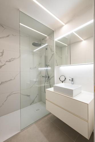 a white bathroom with a sink and a shower at Genieten in Groenendijk Oostduinkerke Koksijde - Vitamine Zee in Koksijde