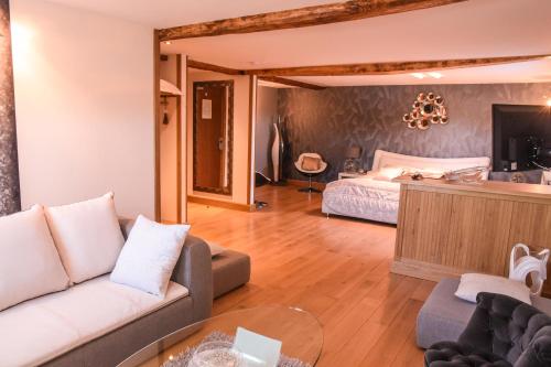 a living room with a couch and a bed at Le Domaine des Fagnes in Sains-du-Nord