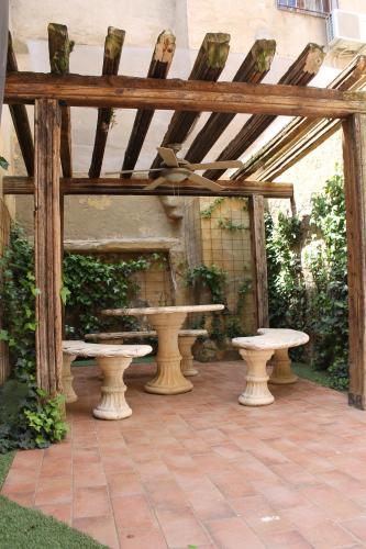 a wooden pergola with a table and benches on a patio at Rey Mundo in Munébrega