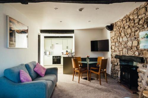 a living room with a blue couch and a table at Rigney Bank House, South Lakes Luxury Apartments in Milnthorpe