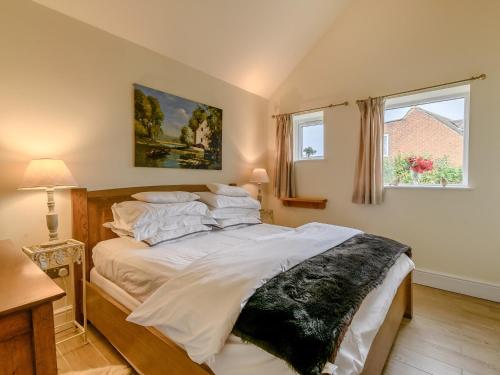 um quarto com uma cama grande e lençóis brancos em 1 Bed in Turnditch PK919 em Turnditch