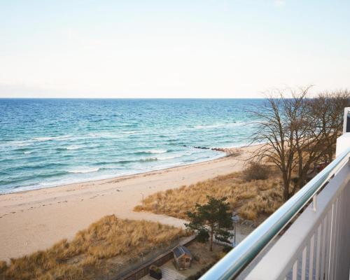 uma vista para a praia a partir de uma varanda em SeeHuus Lifestyle Hotel em Timmendorfer Strand