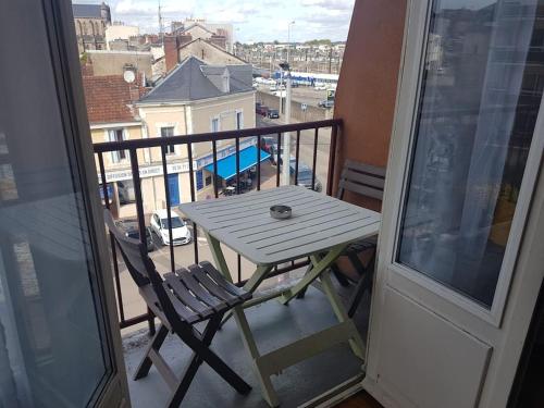 uma mesa branca e cadeiras numa varanda com vista em Appartement T2, très lumineux - à 100m de la gare. em Limoges