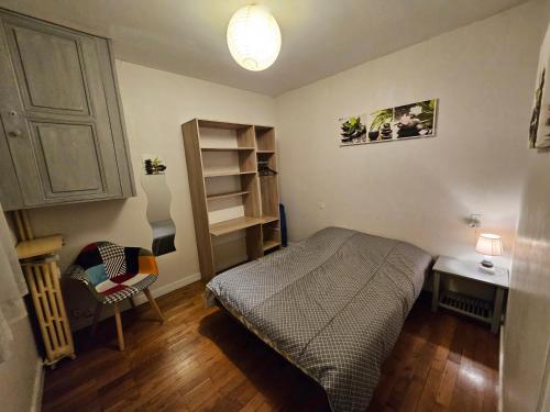 um quarto com uma cama, uma secretária e uma cadeira em Appartement T2, très lumineux - à 100m de la gare. em Limoges