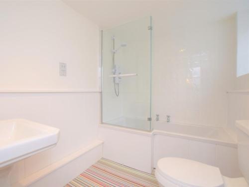 a white bathroom with a toilet and a glass shower at 2 Bed in Appledore 53994 in Appledore