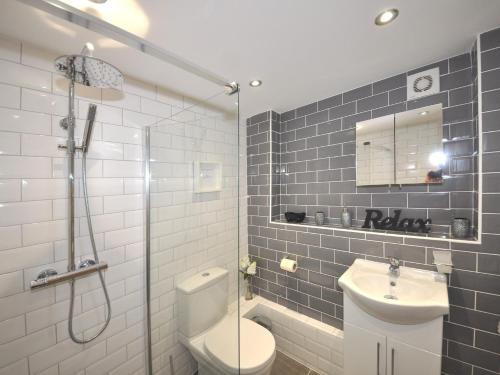a bathroom with a toilet and a sink and a shower at 3 Bed in Brixham BX078 in Brixham