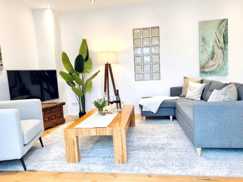 ein Wohnzimmer mit einem Sofa und einem Couchtisch in der Unterkunft Boutique L´AHRpartement Ahr-Terrasse-Zentral in Bad Neuenahr-Ahrweiler