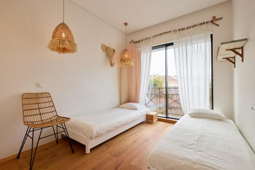 波多的住宿－FLH Secluded Porto Haven with Pool，一间卧室设有两张床、一把椅子和一个窗户。