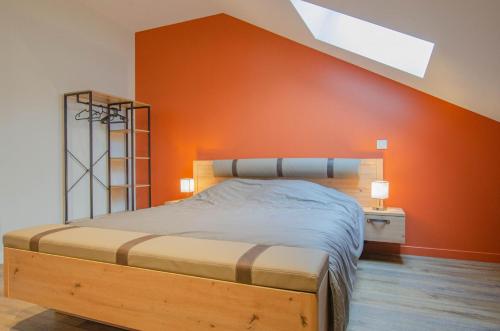 a bedroom with a bed with an orange wall at Escale en champagne 