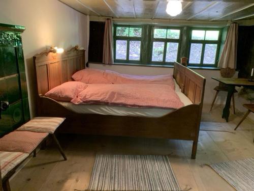 1 dormitorio con 1 cama grande con sábanas rosas en Ferienhaus Hederle en Elzach