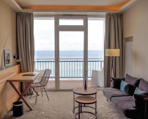 a living room with a view of the ocean at SeeHuus Lifestyle Hotel in Timmendorfer Strand