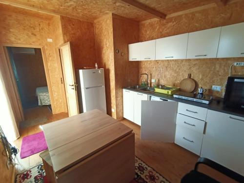 a kitchen with white cabinets and a white refrigerator at Mandulivi, chalet nel mandorleto e mansarda vista mare in Villaggio Azzurro