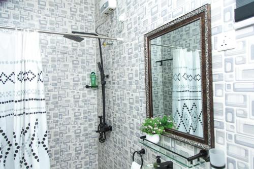 a bathroom with a mirror and a sink at BryMac Hotel in Koforidua