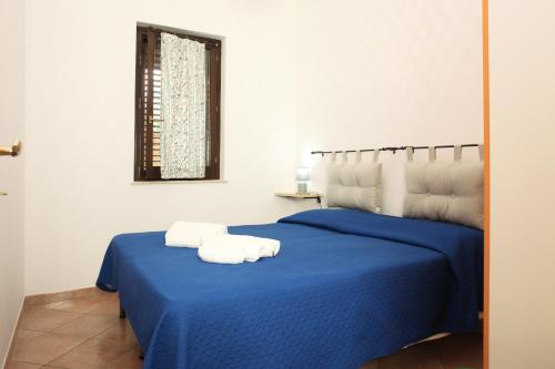 a bedroom with two towels on a blue bed at Acquamarina32 in San Vito lo Capo