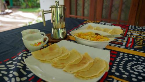 a table with a plate of chips and a bowl of food at Jayanti's in Sigiriya