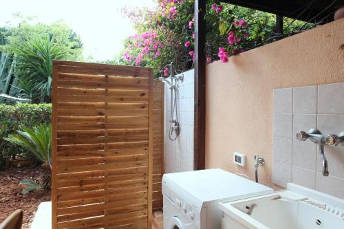 a bathroom with a sink and a washing machine at Acquamarina32 in San Vito lo Capo