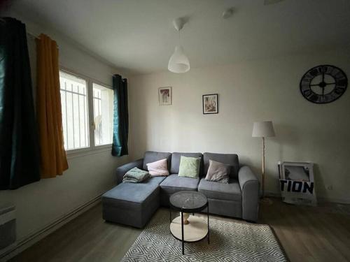 a living room with a couch and a table at Le petit Savigny- proche d'Orly in Savigny-sur-Orge