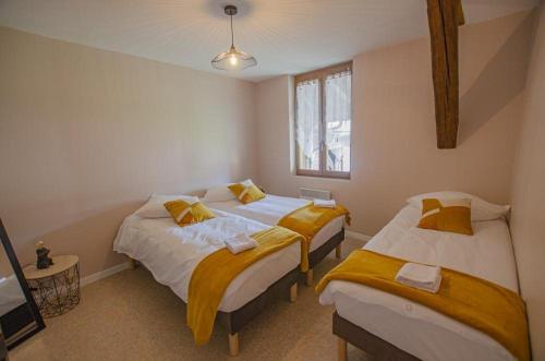 a bedroom with two beds and a window at Le gite du chateau 1 