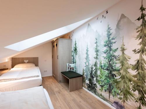 a bedroom with a mural of trees on the wall at Beim Gruber in Rottau